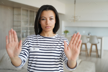 Serious woman showing stop hand gesture protesting against domestic violence, abuse or abortion