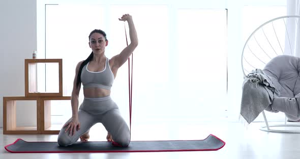 Woman doing exercises with resistance bands at home.