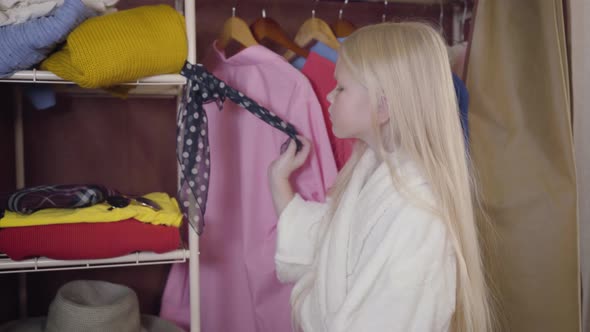 Portrait of Joyful Blond Caucasian Girl in White Bathrobe Putting on Sunglasses and Dancing. Happy