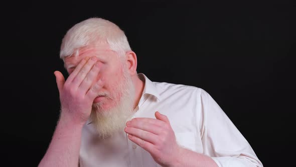 Close Up of an Albino Man Arranging His Beard and Looking at the Camera