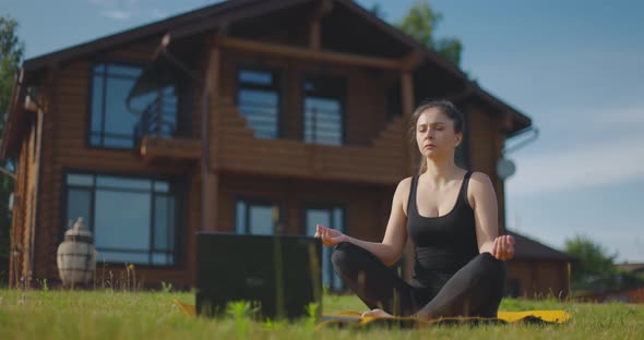 Young Girl Watches Yoga Lessons Online and Meditates