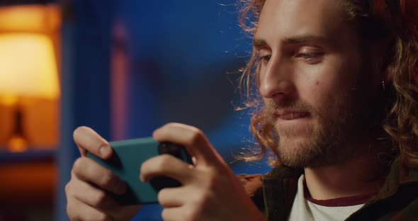 Close Up of Handsome Male Gamer Holding Smartphone Horizontaly and Playing Online Games, Cropped