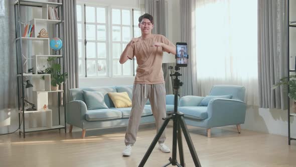 Asian Man Dancing While Shooting Video Content For Social Networks With A Smartphone Camera