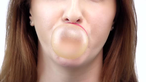 Girl Blowing a Big Bubble Gum Bubble. White Background. Slow Motion