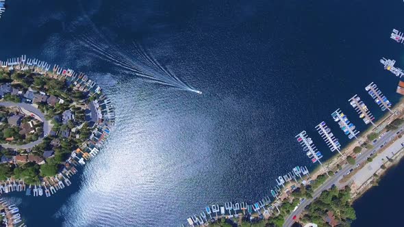 Aerial top down view of the boat sailing to pier Arrowhead Lake, boat and town in California, USA