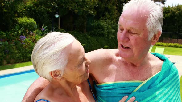 Senior couple kissing each other in the poolside