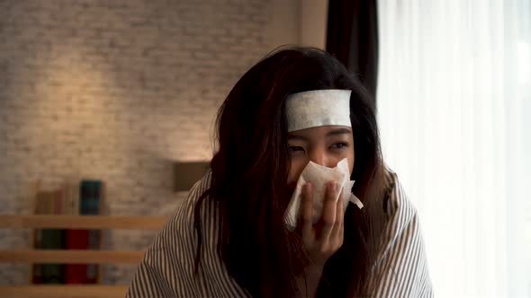 Young Asian Woman Suffering From Cold and Illness and Lying in Bed with Tissue at Home