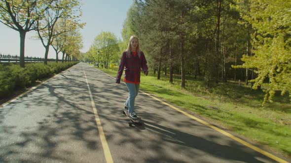 Lovely Positive Cool Female Skateboarding in Public Park