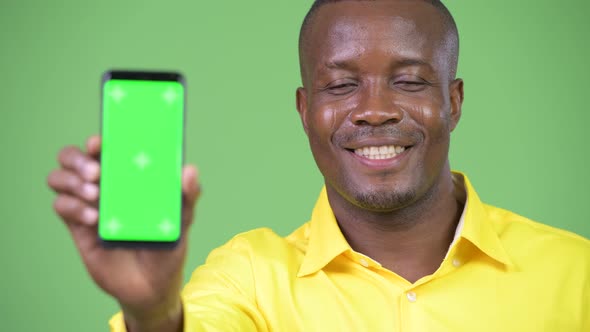 Young Happy African Businessman Showing Phone