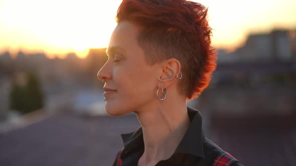 Side View Pierced Caucasian Woman in Golden Sunset Sunrays Turning Looking at Camera Smiling