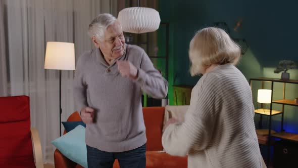 Carefree Senior People Couple Dancing at Home Relaxing Having Fun with Modern Music Smiling at Home