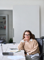 Young happy professional business woman sitting at work desk, portrait. - PhotoDune Item for Sale