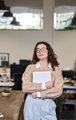 Young dreamy professional business woman standing in modern office thinking. - PhotoDune Item for Sale