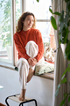 Happy serene young woman sitting relaxing at home looking through window. - PhotoDune Item for Sale
