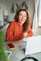 Happy young woman student laughing using laptop sitting at desk studying online. - PhotoDune Item for Sale