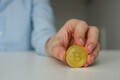 Young man crypto trader holding golden bitcoin on the table. - PhotoDune Item for Sale