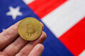 Hand with golden bitcoin and USA flag on background. Crypto investing in United States of America. - PhotoDune Item for Sale