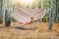 Cute little boy lying on big hammock in birch grove. Child smiling, camping life - PhotoDune Item for Sale