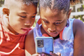 mobile phone handled by interested multiethnic children - PhotoDune Item for Sale