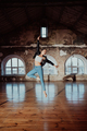 Woman jumping in casual style doing ballet in old studio. Attractive ballerina - PhotoDune Item for Sale