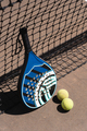 Padel racket and balls near net - PhotoDune Item for Sale