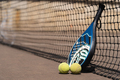 Padel racket and balls near net - PhotoDune Item for Sale