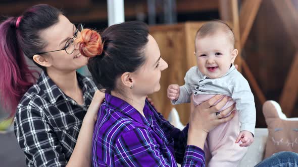 Two Young Informal Caring Woman Enjoying Motherhood Playing with Happy Child Medium Closeup