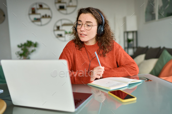  on computer at home. Young woman using laptop remote working, talking having web conference meeting, virtual class, communicating by video call.