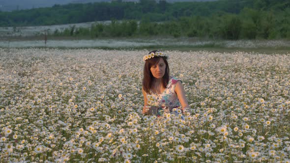 Beautiful Girl in Meadow of Camomile Flower