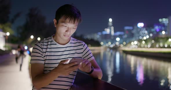 Man use of smart phone in city at night
