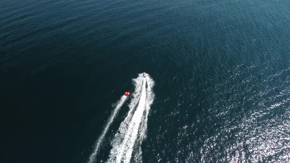 Happy People Swim on Air Mattress Behind a High Speed Water Bike