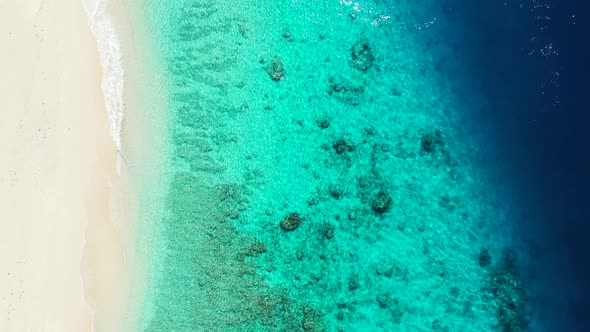 Daytime drone island view of a white sandy paradise beach and aqua blue ocean background in colorful