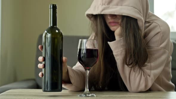 Unkempt Woman Drinking Wine Alone