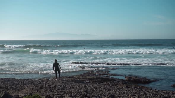 Surfer Standing on Coast