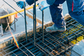 Construction worker using safety rules is working on a reinforced concrete slab preparing rebar - PhotoDune Item for Sale