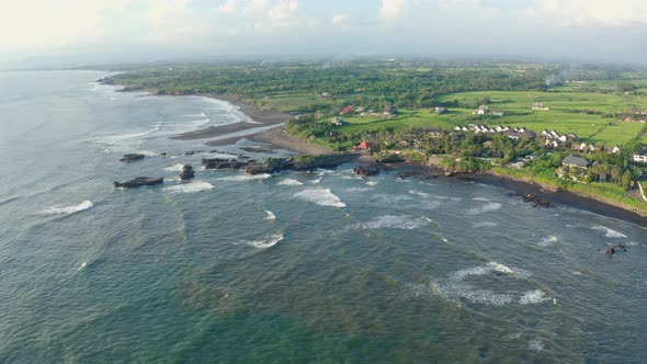 Aerial Footage of Black Volcanic Beach, Green Rice Terraces. Bali, Indonesia