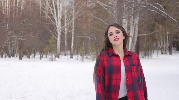 Female in Checkered Shirt Walking in Snowy Park