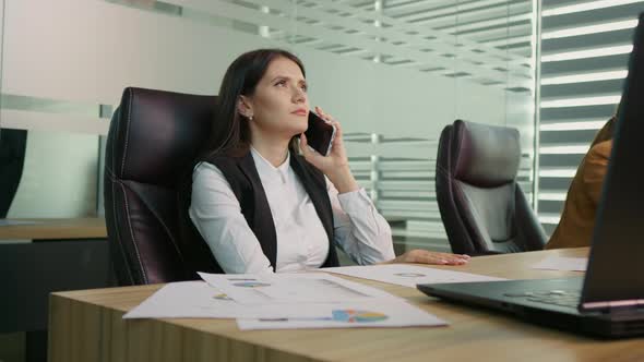 Businesswoman dial phone number written on a paper making the phone call.