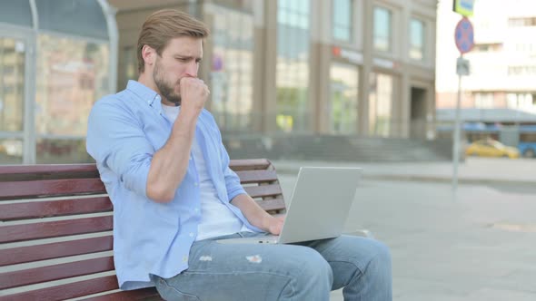 Coughing Man Using Laptop While Sitting Outdoor on Bench