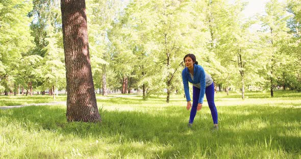 A 35Yearold Woman Practices Yoga in a City Park