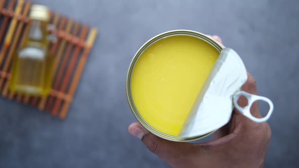 Holding Homemade Ghee in Container on a Table 