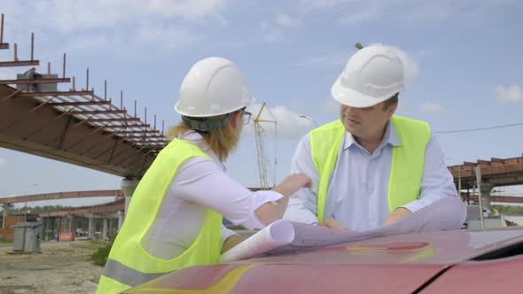 Male and female engineers are discussing a flyover construction project.