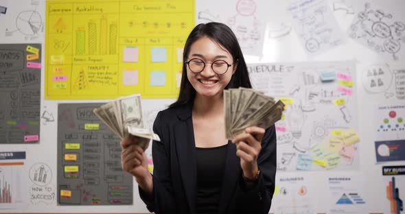 Successful asian businesswoman glasses throwing banknotes