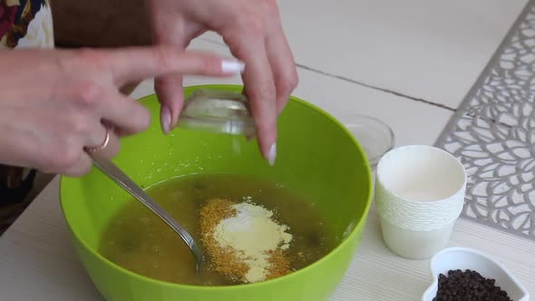 A Woman Prepares Muffins With Chocolate And Raisins.