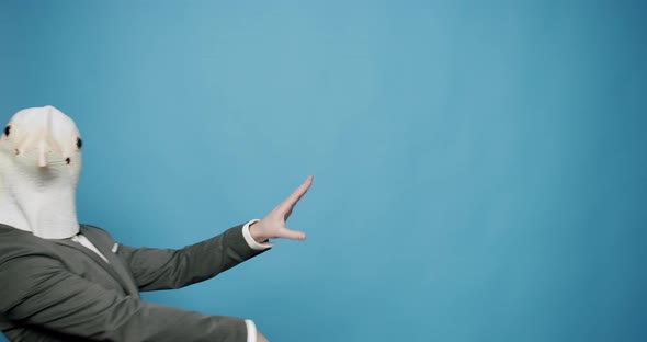 Happy Guy Enjoying Dance with Pigeon Mask on Blue Background