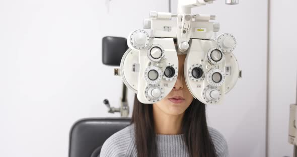 Woman checking on eye in clinic