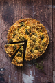 Top down view of a delicious broccoli quiche on wooden table, with piece cut out - PhotoDune Item for Sale