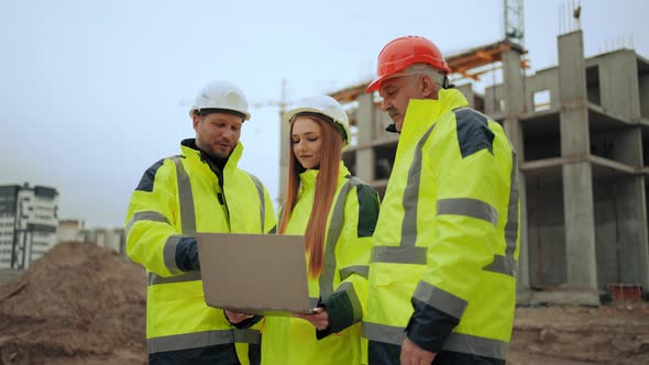 Three Engineers are Discussing Project of Building and Construction Progress in Building Site