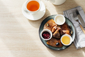 Delicious thin pancakes with jam, honey and sour cream and cup of tea on light wooden table - PhotoDune Item for Sale