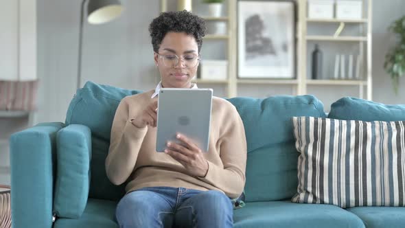 Young African Girl is Scrolling Her Tablet